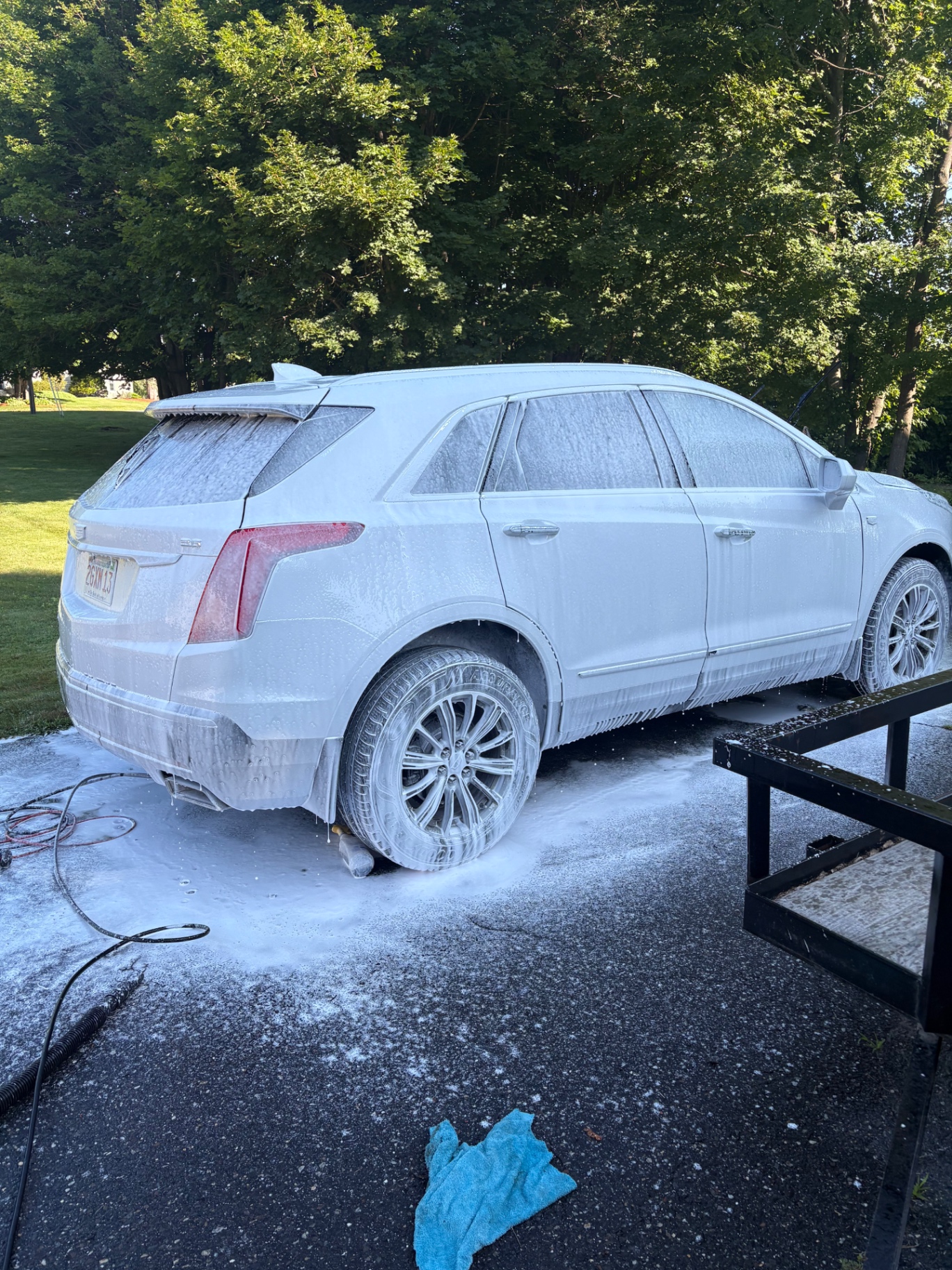 White Cadillac SUV covered in cleaning foam